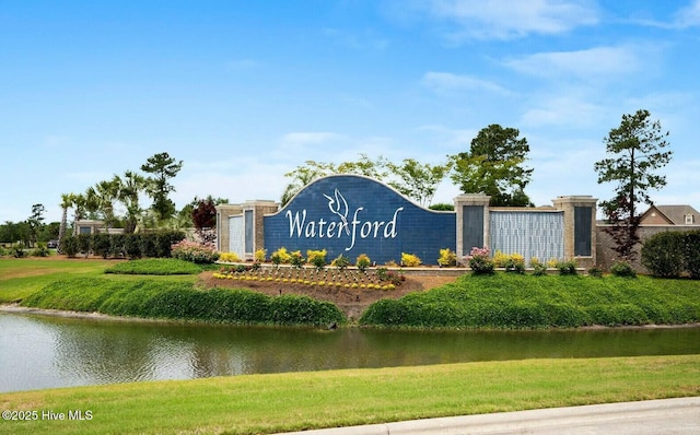 community / neighborhood sign with an attached garage and a water view