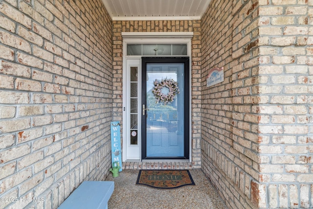 entrance to property featuring brick siding