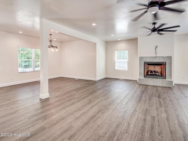 unfurnished living room with recessed lighting, a fireplace, baseboards, and wood finished floors