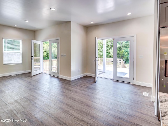 interior space with wood finished floors, baseboards, and a wealth of natural light