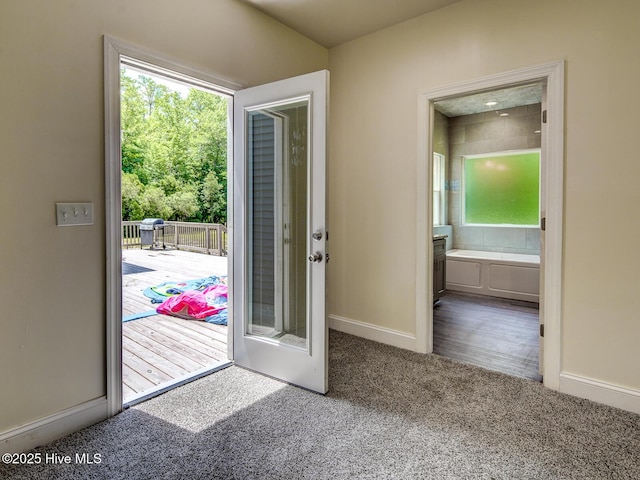 doorway to outside with baseboards and carpet floors