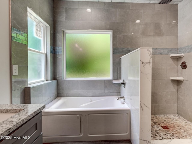 bathroom featuring vanity, a garden tub, and a walk in shower