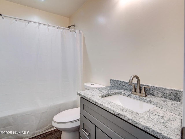 bathroom featuring shower / bath combination with curtain, toilet, vanity, and wood finished floors