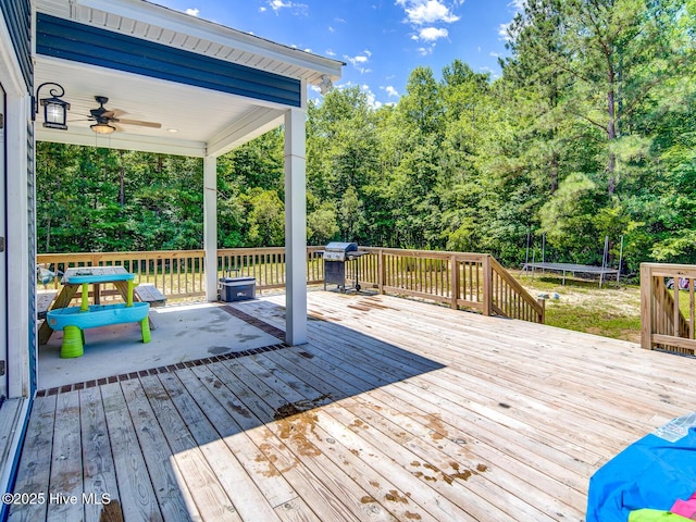 deck with area for grilling, ceiling fan, and a trampoline