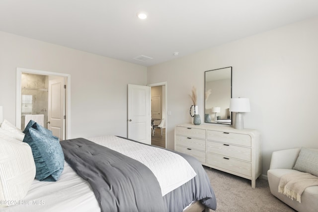 bedroom with light colored carpet, visible vents, and connected bathroom