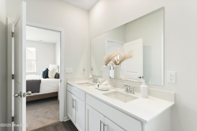 ensuite bathroom featuring double vanity, wood finished floors, ensuite bath, and a sink