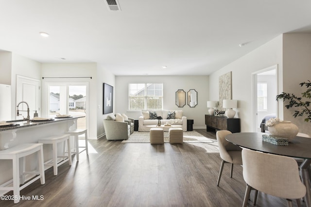 living area featuring dark wood-style floors, visible vents, and baseboards