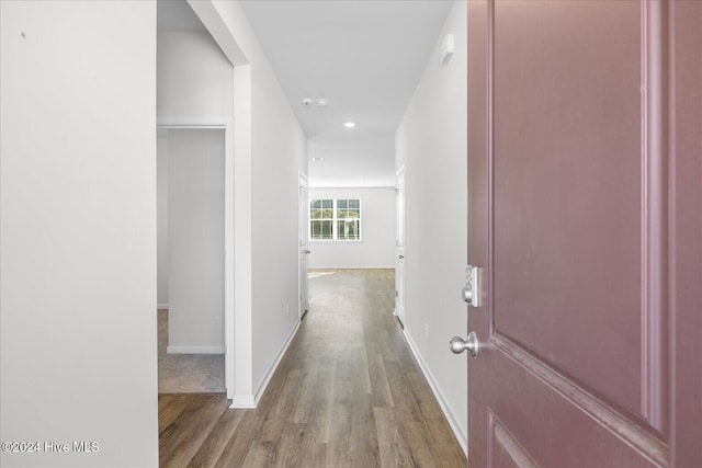 hall featuring baseboards and wood finished floors