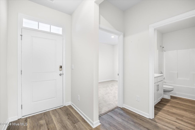 foyer with baseboards and wood finished floors