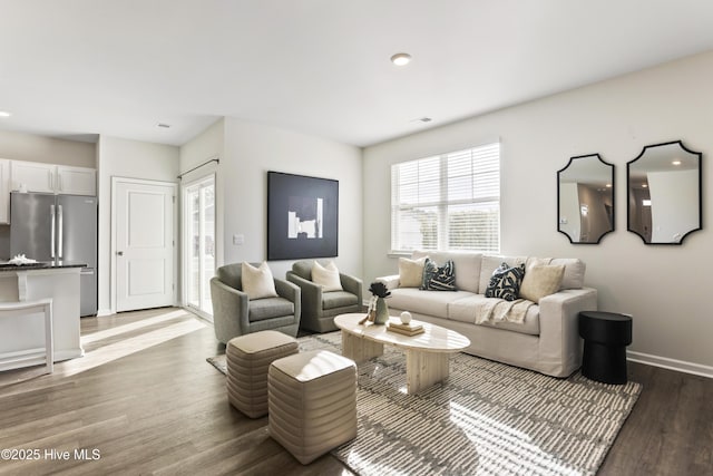 living area with visible vents, baseboards, and wood finished floors