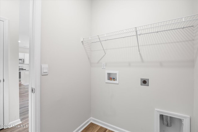 laundry room featuring baseboards, washer hookup, laundry area, wood finished floors, and hookup for an electric dryer