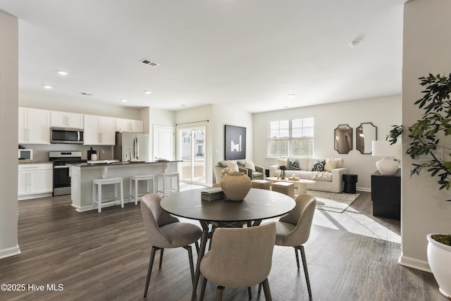 dining area with dark wood finished floors, visible vents, recessed lighting, and baseboards