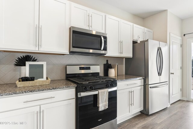 kitchen featuring decorative backsplash, white cabinets, and appliances with stainless steel finishes