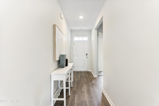 corridor with baseboards and dark wood-style flooring