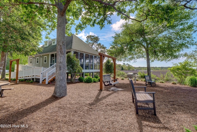 view of playground with stairs and a sunroom