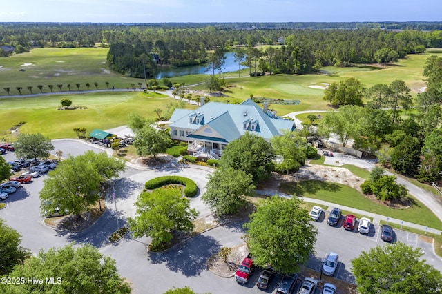 drone / aerial view featuring a forest view, a water view, and view of golf course