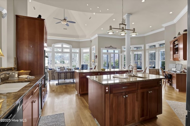 kitchen with a kitchen island with sink, dishwashing machine, ornamental molding, and a sink