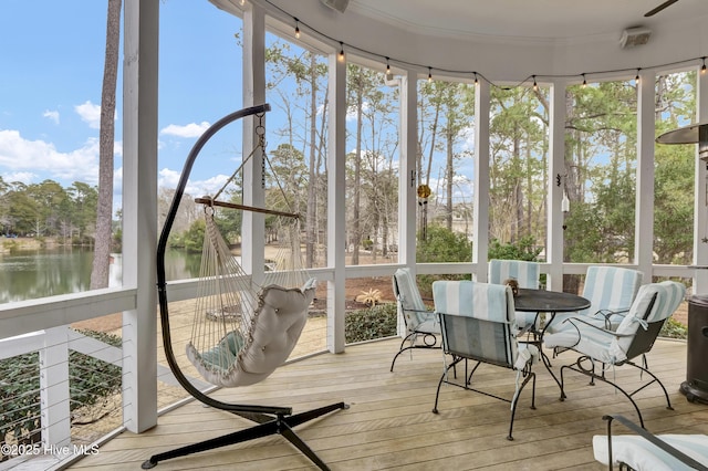 sunroom / solarium featuring a water view