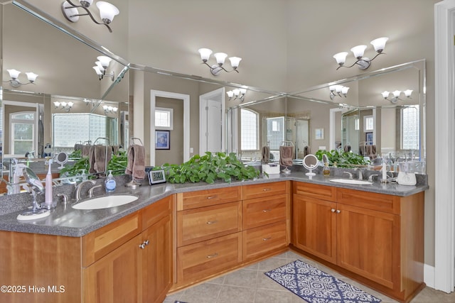 full bathroom featuring tile patterned floors, a notable chandelier, double vanity, and a sink