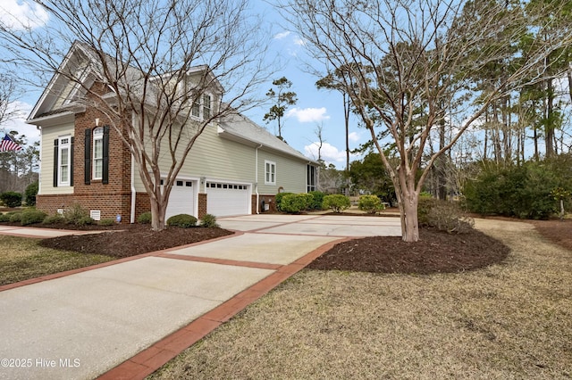 view of side of home with concrete driveway, brick siding, and crawl space