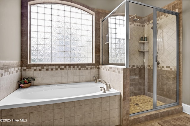 full bathroom featuring a garden tub and a shower stall