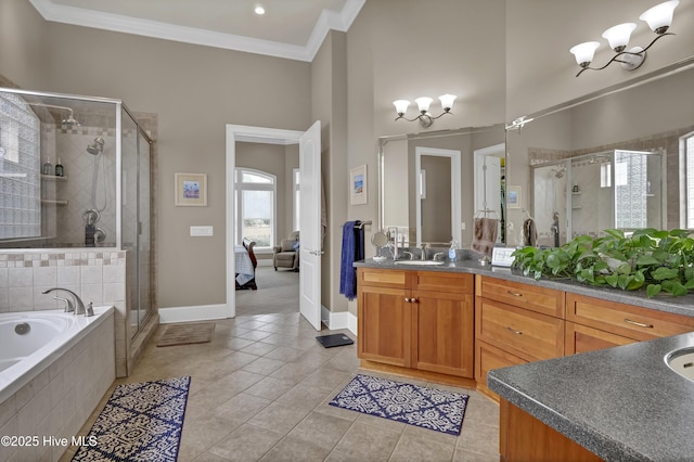 ensuite bathroom with tile patterned floors, a stall shower, crown molding, a bath, and vanity