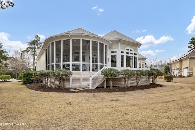 back of house with roof with shingles and a sunroom