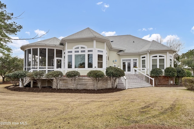 back of house featuring a yard, french doors, a sunroom, and roof with shingles