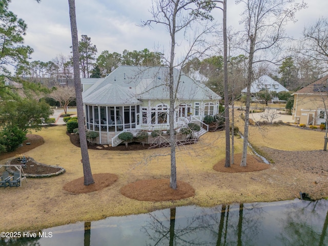 rear view of property featuring a sunroom