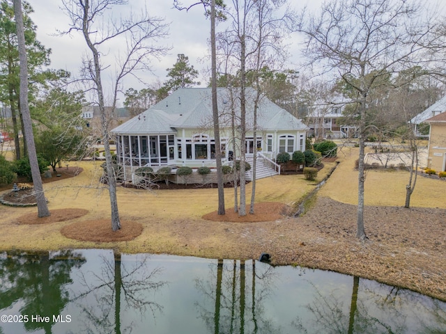 back of property featuring a water view and a sunroom