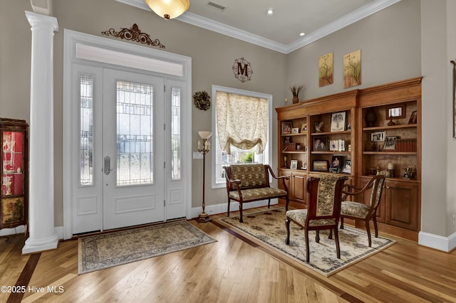 entrance foyer with light wood-type flooring, decorative columns, and plenty of natural light