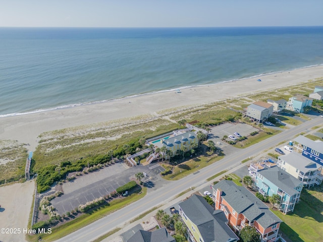 drone / aerial view featuring a residential view, a water view, and a view of the beach