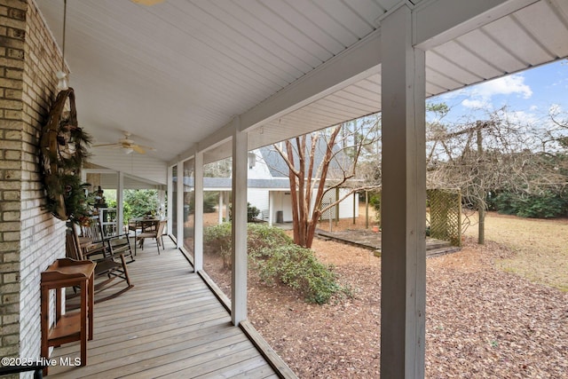 wooden deck featuring covered porch and a ceiling fan