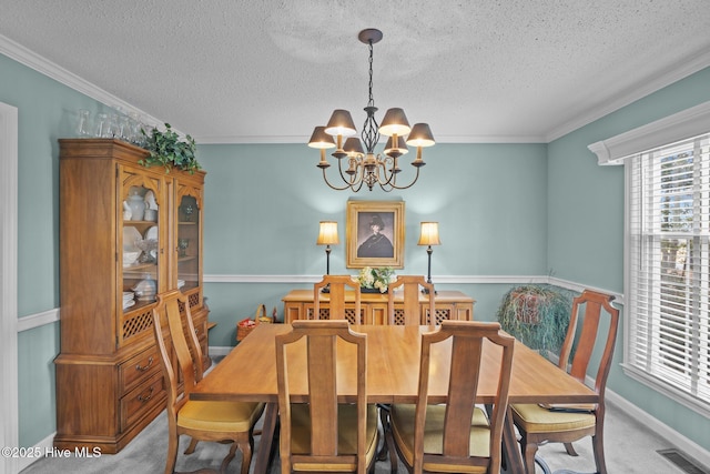 carpeted dining area with visible vents, crown molding, baseboards, an inviting chandelier, and a textured ceiling