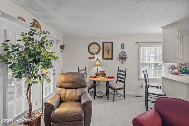 dining room with light colored carpet, a textured ceiling, crown molding, and baseboards