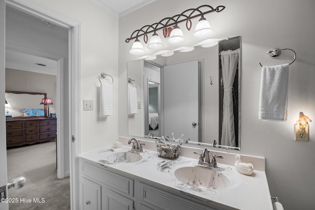 ensuite bathroom featuring double vanity, connected bathroom, ornamental molding, and a sink