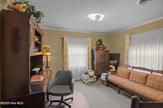 carpeted home office with visible vents, a textured ceiling, and crown molding