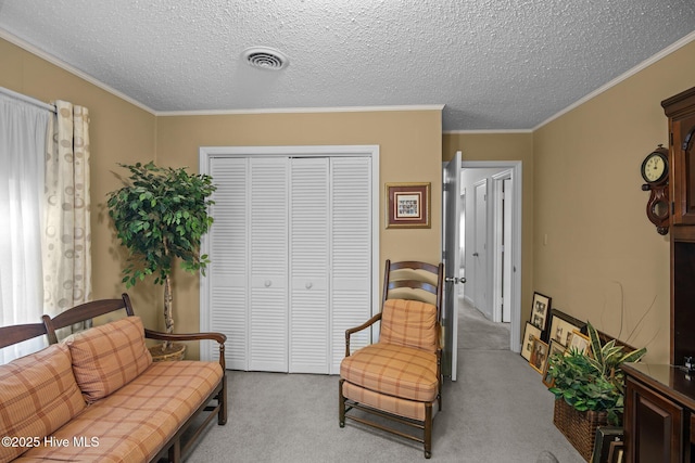 sitting room featuring visible vents, ornamental molding, a textured ceiling, and carpet floors