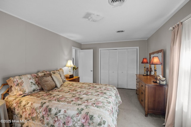 bedroom with visible vents, a closet, and light carpet