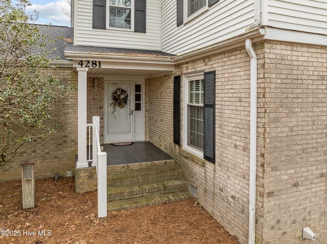 doorway to property featuring brick siding