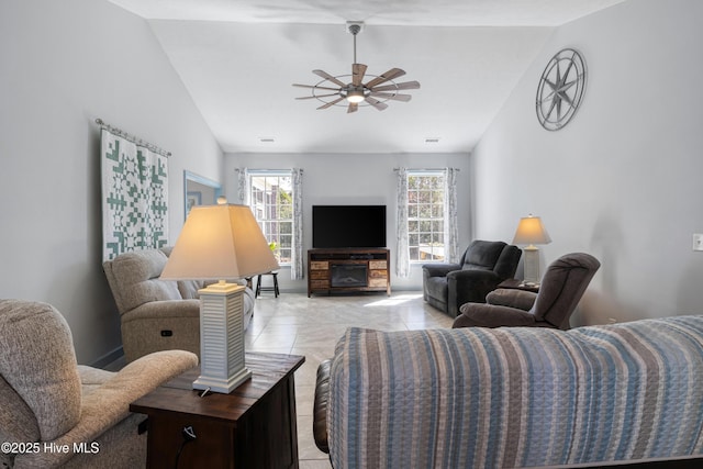 living area with vaulted ceiling, light tile patterned flooring, and a ceiling fan