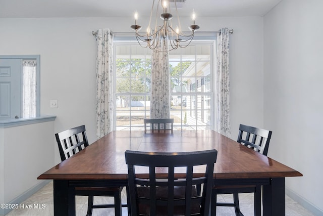 dining area with baseboards and an inviting chandelier