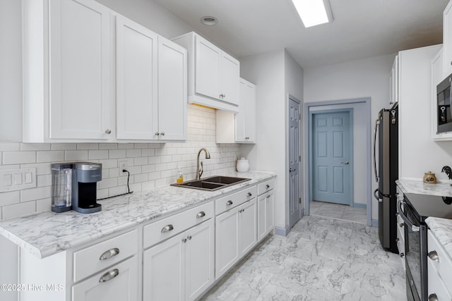 kitchen with marble finish floor, appliances with stainless steel finishes, white cabinets, and a sink