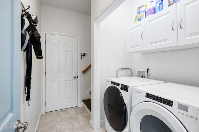 washroom featuring cabinet space and washer and clothes dryer