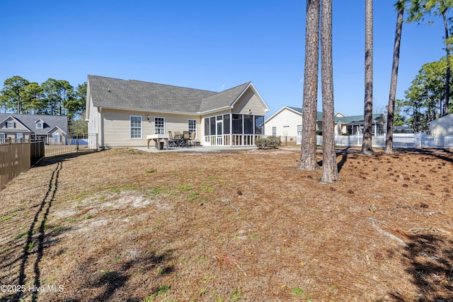back of property with a patio, a fenced backyard, and a sunroom