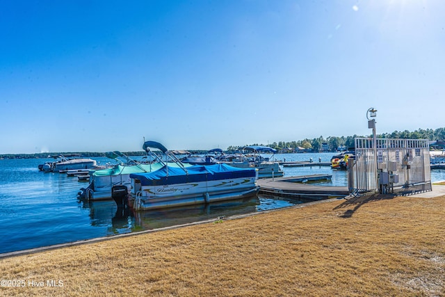 view of dock featuring a lawn and a water view