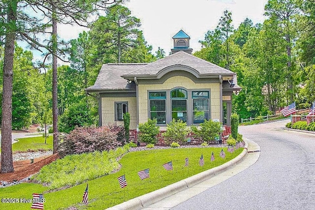 exterior space with a front yard and a shingled roof