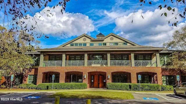 view of front facade with uncovered parking and brick siding