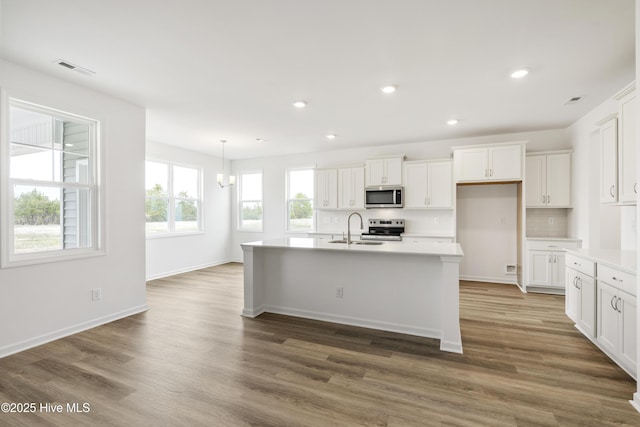 kitchen featuring decorative backsplash, white cabinetry, appliances with stainless steel finishes, and a sink