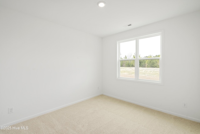 empty room with visible vents, baseboards, and light colored carpet